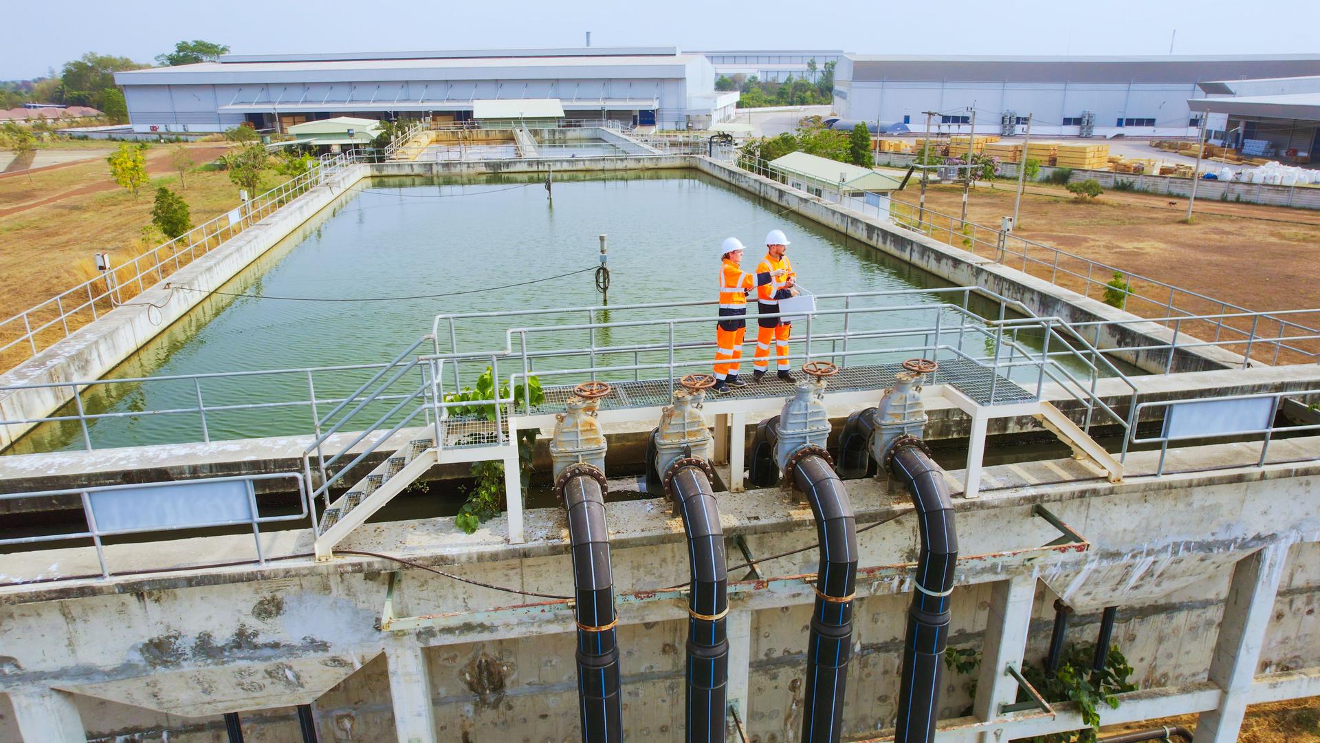 Aerial View of Two Environmental engineers work at wastewater treatment plants, Water management concept.